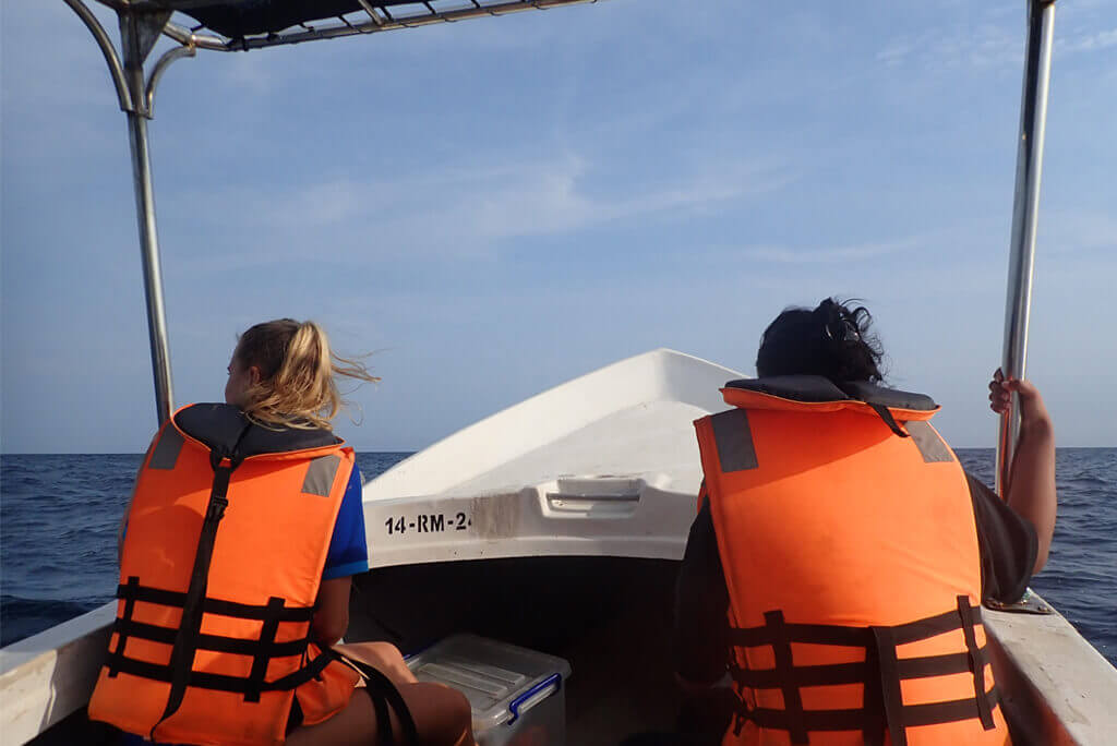 two people sitting on boat in life jackets searching for dolphins and blue whales in Trincomalee east coast Sri Lanka - The best whale watching tours 