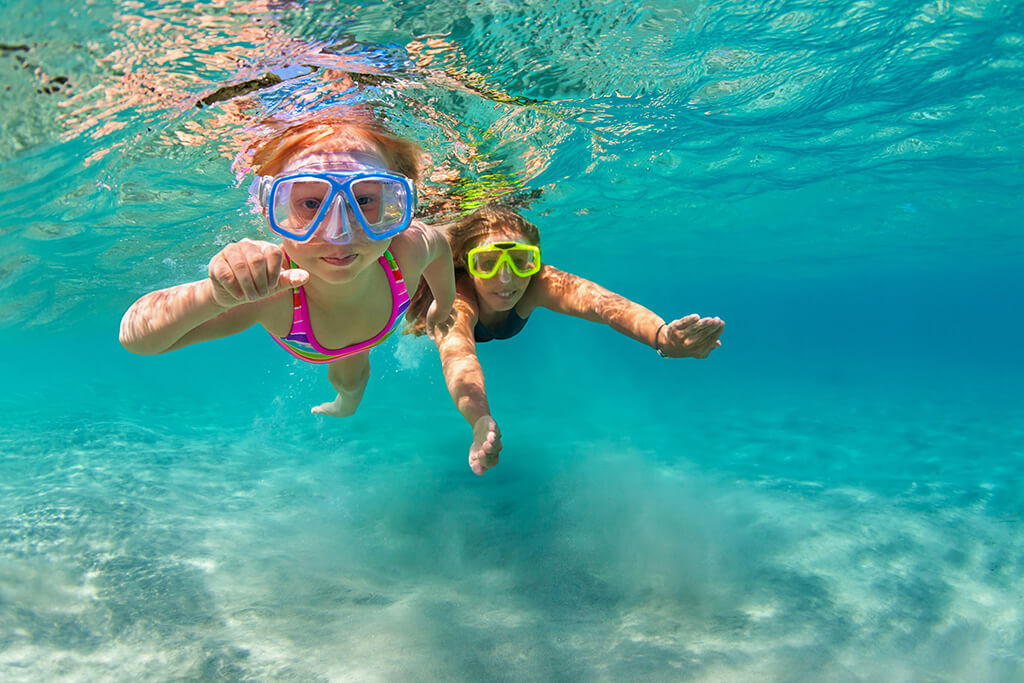 Happy family - mother with baby girl dive underwater with fun in sea pool. Healthy lifestyle, active parent, people water sport outdoor adventure, swimming lessons on beach summer holidays with child