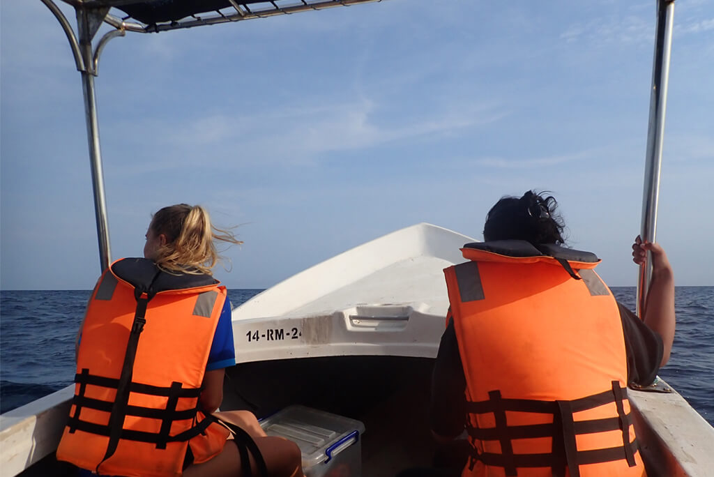 two people on boat in life jackets on whale watching tour in Trincomalee on east coast of Sri Lanka with Divinguru